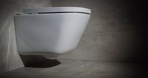 Modern White Toilet Mounted on Gray Tiled Wall
