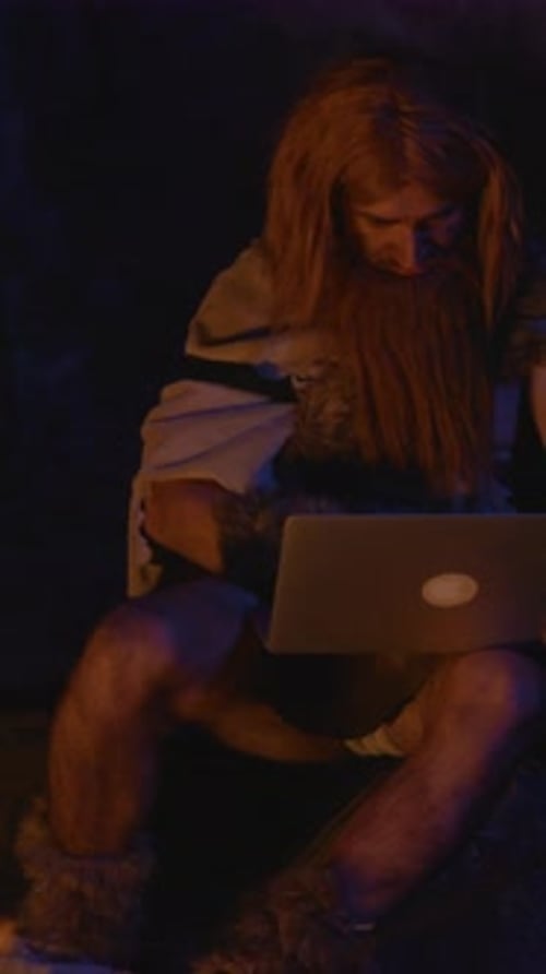 Long-Haired Person in Cave Using Laptop