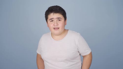 Teenager Standing and Talking Against a Blue Background