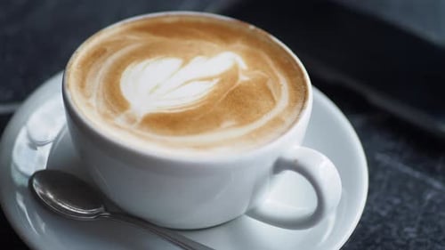 Enjoying Latte Art at a Cozy Cafe in the Morning