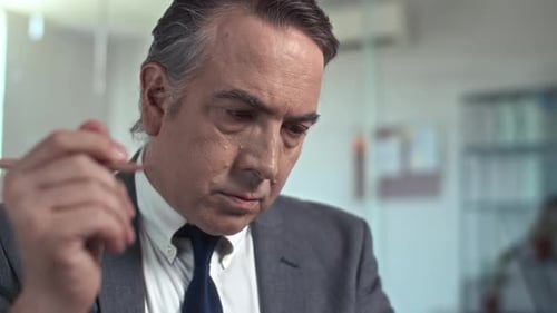 Close Up of Senior Businessman Working on Report in Office