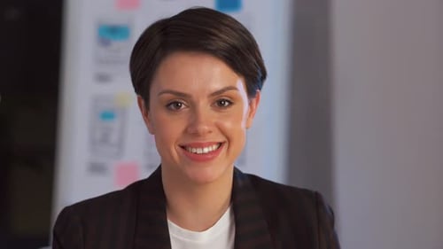 Happy young businesswoman smiling in a night office corporate portrait slow motion