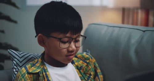 Asian boy wearing glasses schoolboy using a laptop computer
