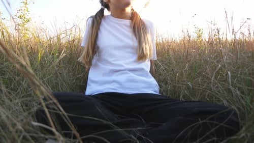 Portrait of Beautiful Smiling Girl Sitting on Grass at Field Happy Small Kid Looking Into Camera