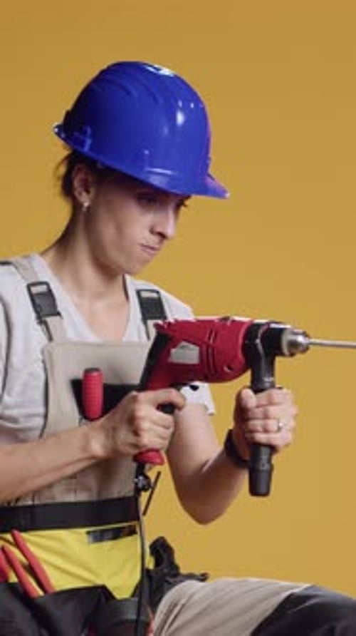 Vertical Video Strong Handywoman Drilling Nails with Power Drill Gun