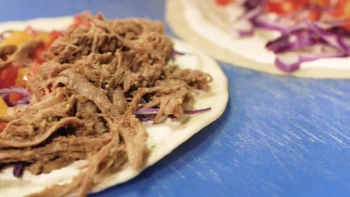Hands Preparing Delicious Wraps with Meat and Vegetables
