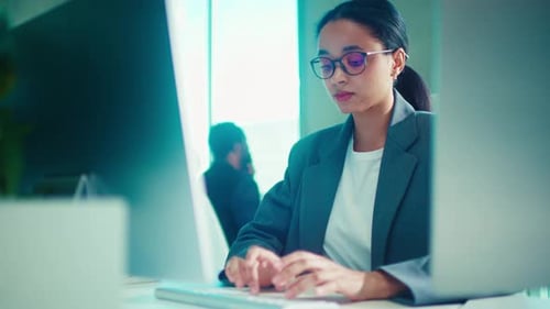 Professional Woman Focused on Work at a Modern Office Desk