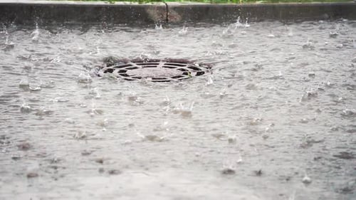 Água pesada da chuva escorre para os drenos, câmera lenta