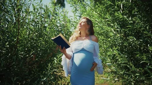 Pregnant Woman Enjoying Nature and Reading in a Lush Green Setting