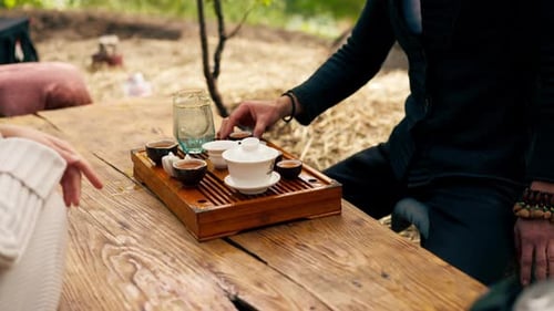 close-up The hands of a professional tea master who pours fresh natural green tea from a glass