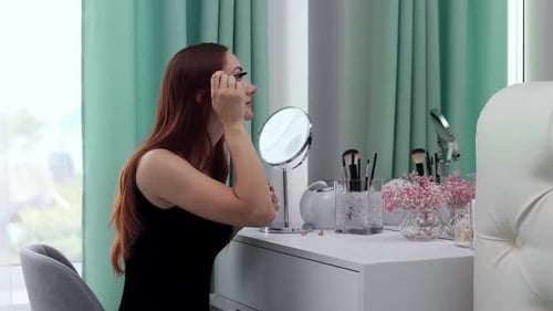 Woman Applies Mascara at Vanity Table