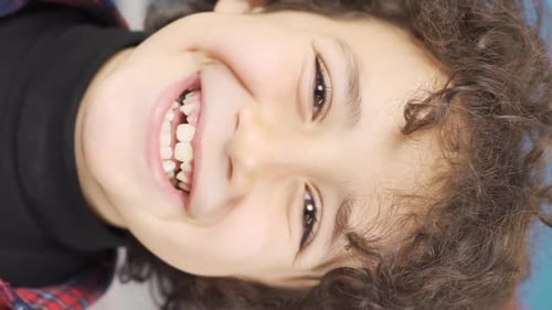 Vertical Video of Close-up of boy smiling at camera. Happiness.