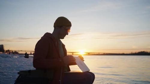 Professional Freelancer Working Remotely on Laptop Near River During Golden Sunset Embodying Digital