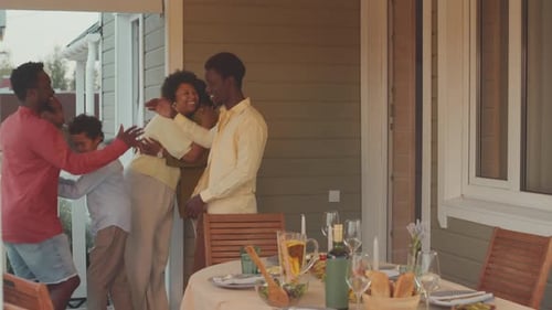 Family and Friends Share Warm Hugs on Sunny Porch