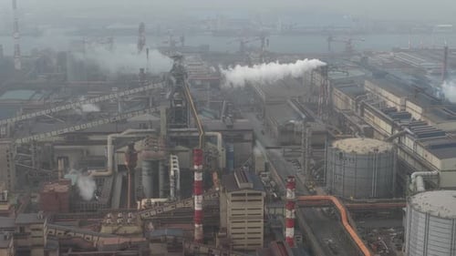 Aerial view of industrial plant emitting smoke and steam