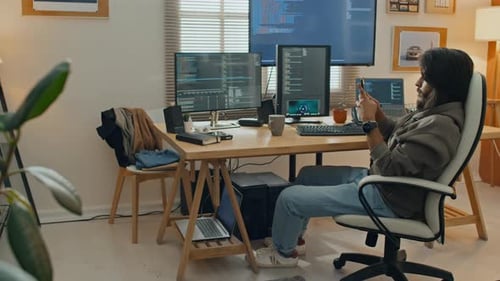 Junger Programmierer tippt auf dem Smartphone, während er von zu Hause aus arbeitet
