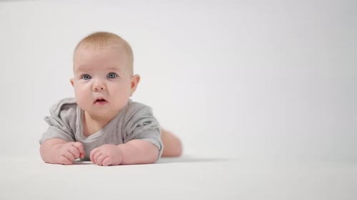 Portrait of a baby. A baby lying on his stomach in close-up against a white background,