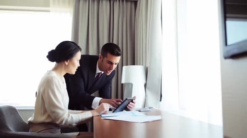 Hispanic business team collaborate with tablet pc at hotel room on trip