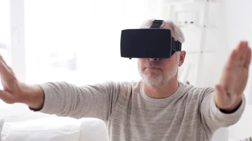 Senior Man Experiencing Virtual Reality Headset in Home