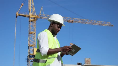 African American Man Types Report About Building at Sunlight