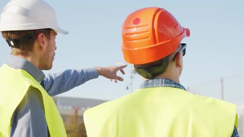 Professional Builders Standing in Front of Construction Site Office Building and Crane Background