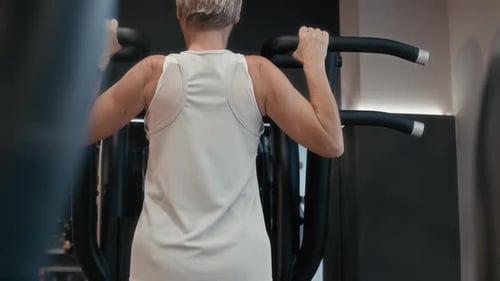 Athletic Woman Practicing Pull Ups Using Gym Equipment