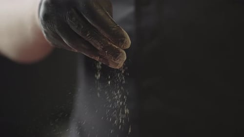 Hand Sprinkles Seasoning on Meat