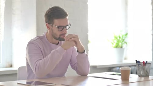 Young Man Feeling Worried While Sitting in Office