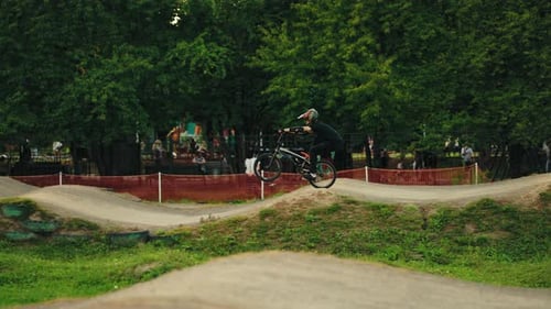Sporty Guy is Riding on One Wheel of Bike on BMX Track Performing Trick Practicing Before Racing