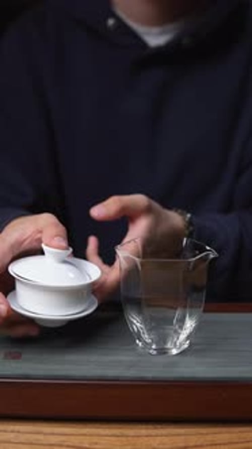 Tea Pouring From Cup into Glass Container