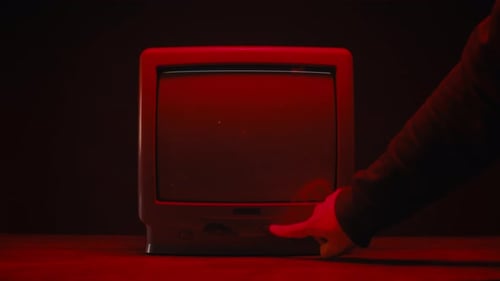 Hand Pushes Power Button on Old Television with Static