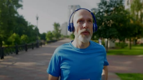 Man Runs Energetically Through Sunny Urban Park