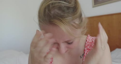 Sad Woman Massaging Head in a House