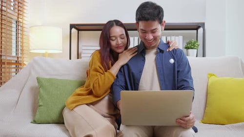 Happy Couple Use Laptop Together at Home