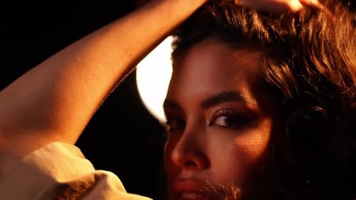 Woman Posing Glamorously in Studio with Mood Lighting