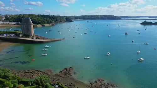 Downward drone movement near the Intra Muros fortified coastline with yachts, Saint-Malo, France.