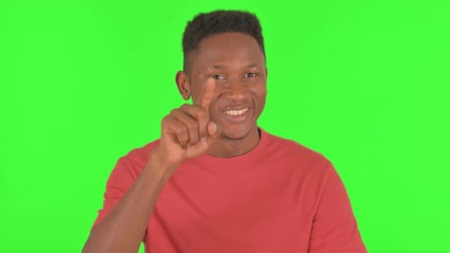 Portrait of African Man Pointing at Camera on Green Background