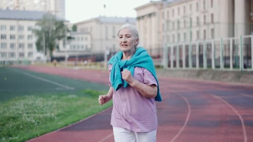 Old lady run stadium. Elderly woman jog arena. Senior granny sportsman workout.