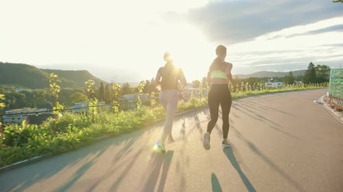 Junge Sportlerinnen, die die Straße entlang laufen und hart trainieren, um sich auf den Wettkampf vorzubereiten oder