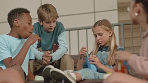 Multiracial Kids Talking during School Lunch Outdoors