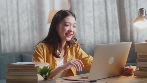 Smiling Woman Video Chatting on Laptop at Desk