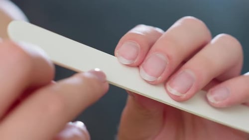 Close Up Fingernail Filing with White Filer on Natural Nails