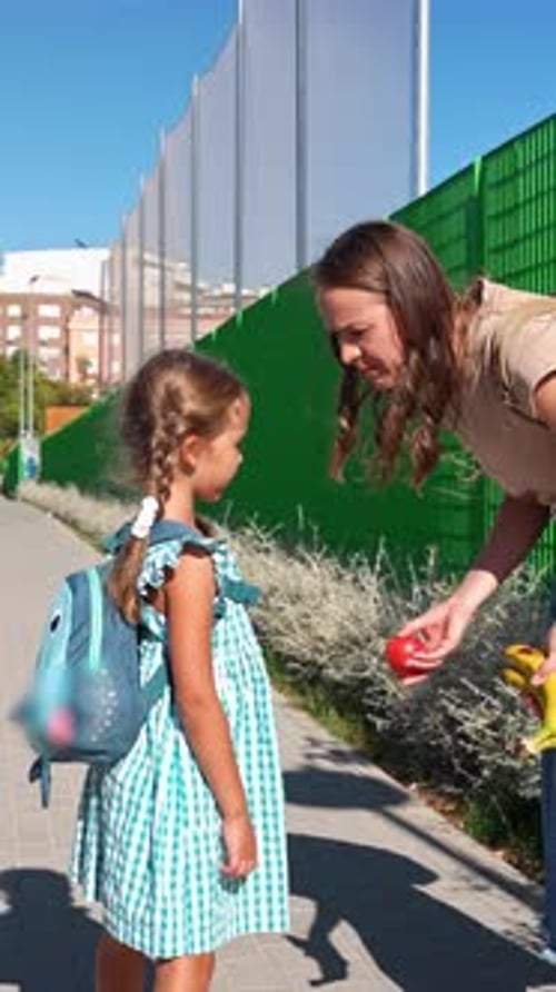 Madre cariñosa le da un refrigerio saludable de frutas a su hija antes de la escuela