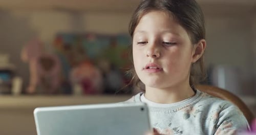 Authentic shot of little smiling girl pupil is making a video call with laptop for having a lectur