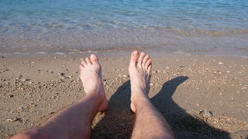 Man is relaxing barefoot at the beach