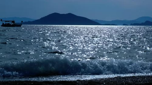Silhouette of a Boat Sailing at Sunset on the Sea