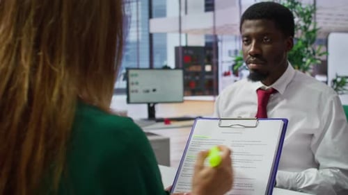 Woman and Man in Office Discussing Document