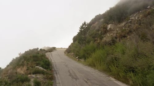 Drone flying over an abandoned asphalt mountain road. Aerial view of a mountain road in San Gabriel