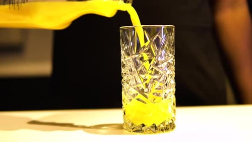 Bright Yellow Juice Being Poured into Glass