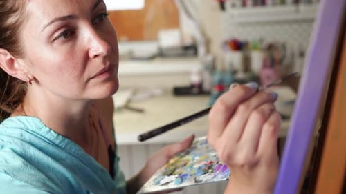Talented Female Artist Painting Canvas in Creative Studio